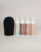 Gant applicateur d'autrobronzant positionné à côté de la collection complète de produits autobronzants de la maque québécoise TravelMe, sur un fond blanc. Des produits  intégrer naturellement à sa routine bien-être.