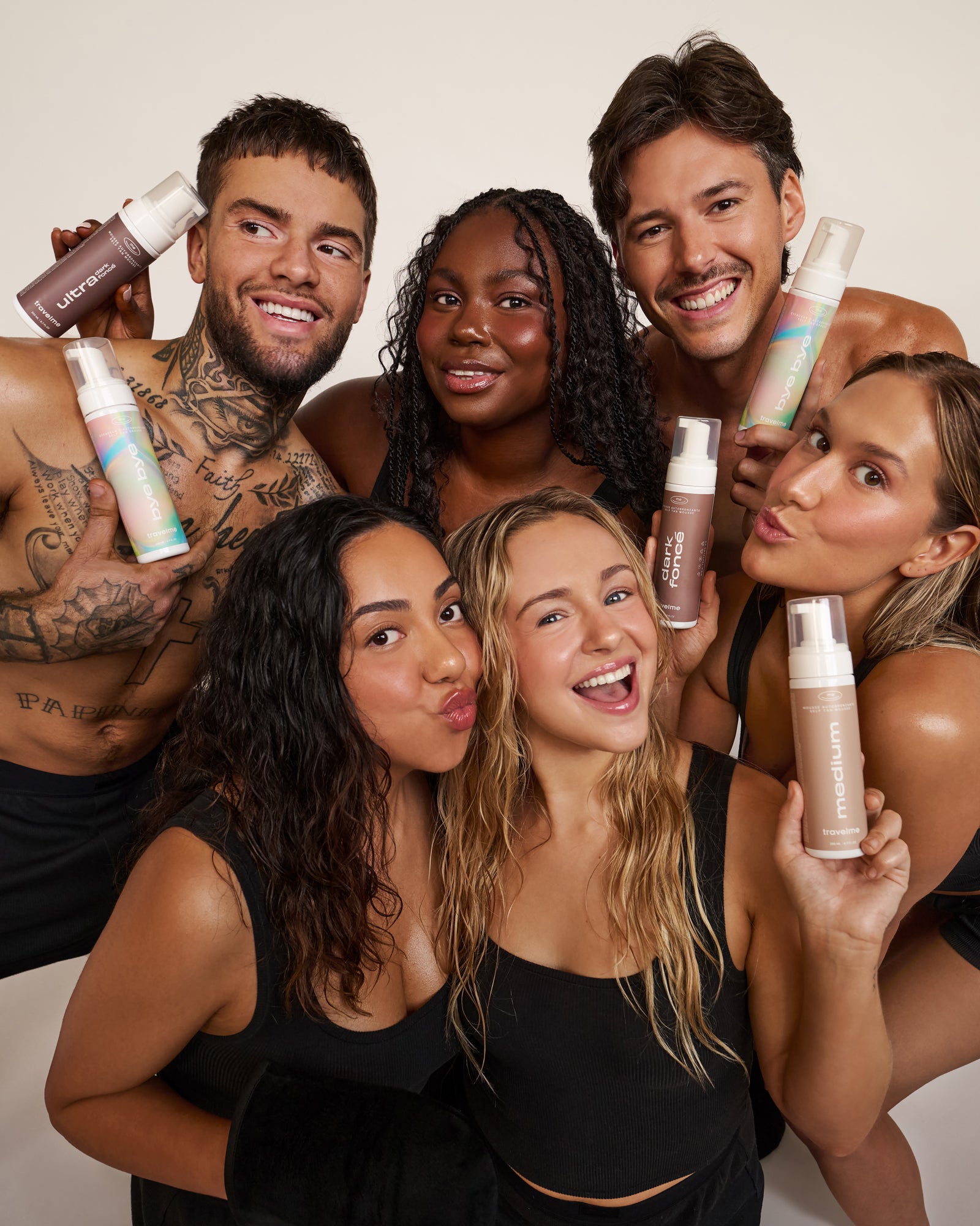 Groupe de femmes et hommes, tout en sous-vêtements noirs, qui posent avec les nouveaux produits autobronzants de Travel Me. Marque self-care québécoise.