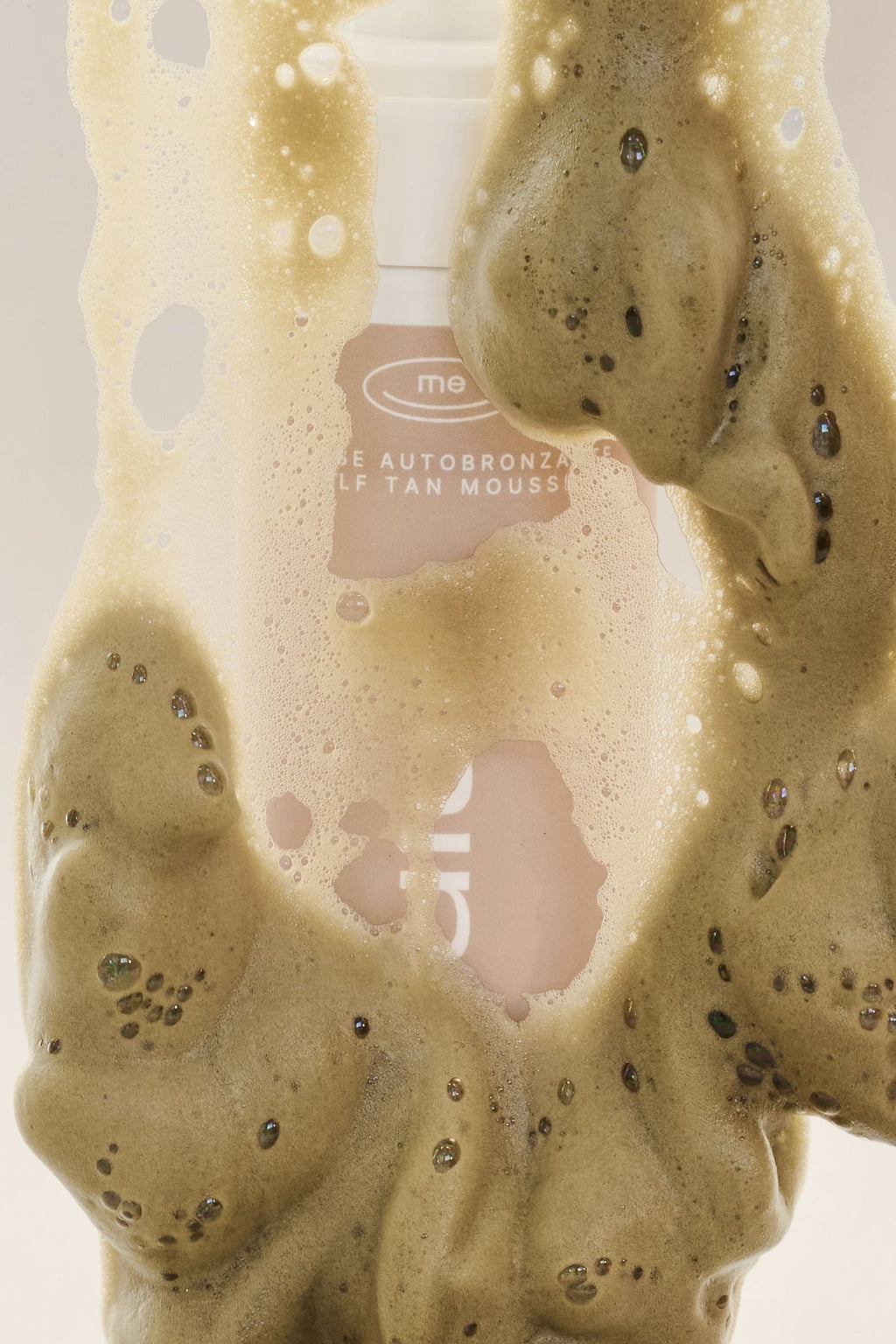 Mousse autobronzante Médium, avec de la mousse autour, de l'entreprise québécoise TravelMe, sur un fond blanc.