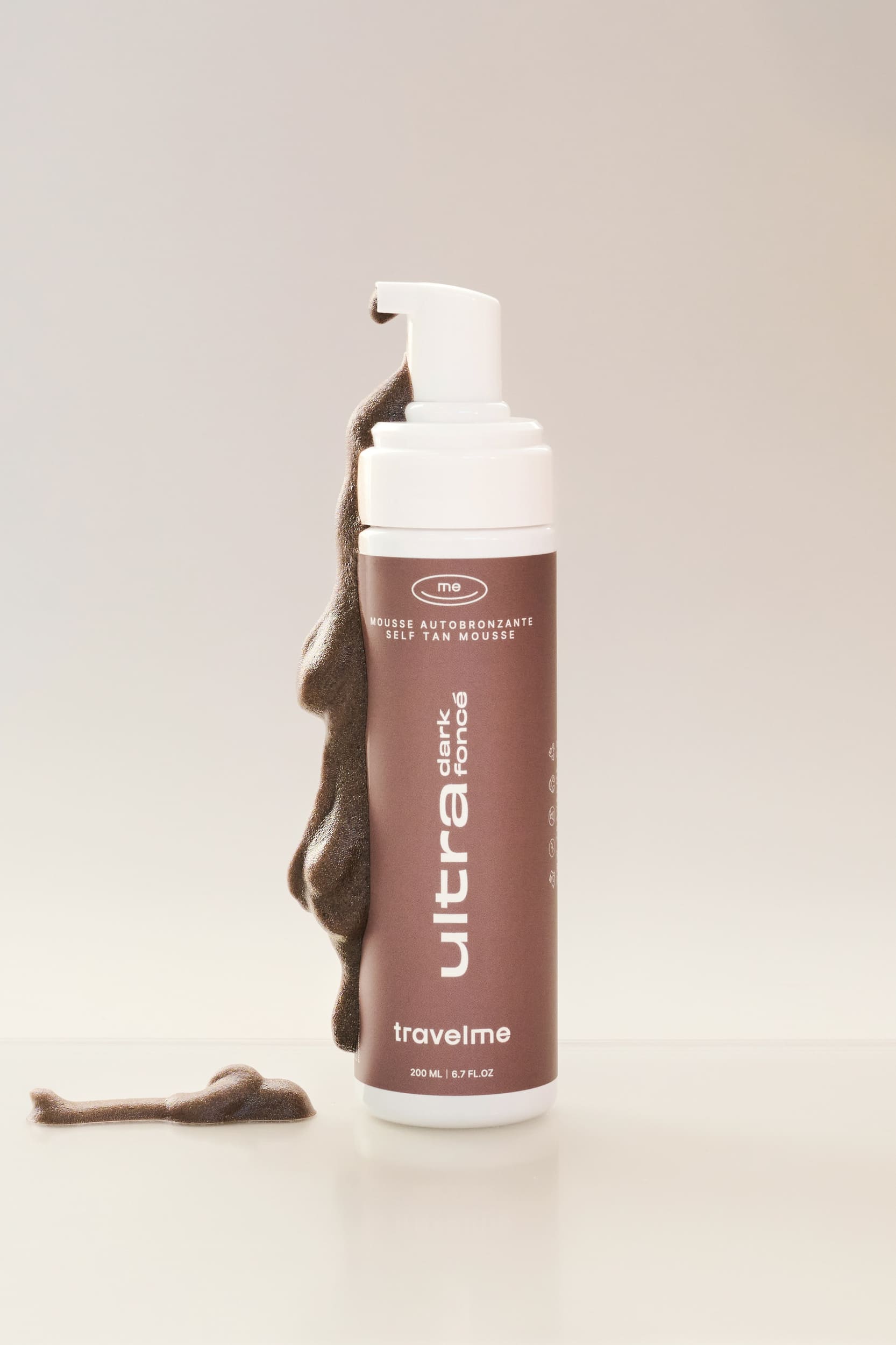 Mousse autobronzante Ultra Foncé, avec de la mousse qui coule, de l'entreprise québécoise TravelMe, sur un fond blanc.